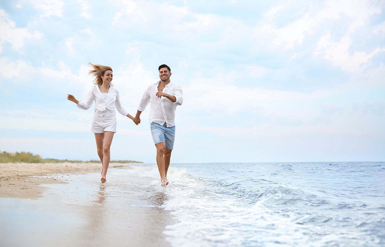 běžící pár ve vlnách moře